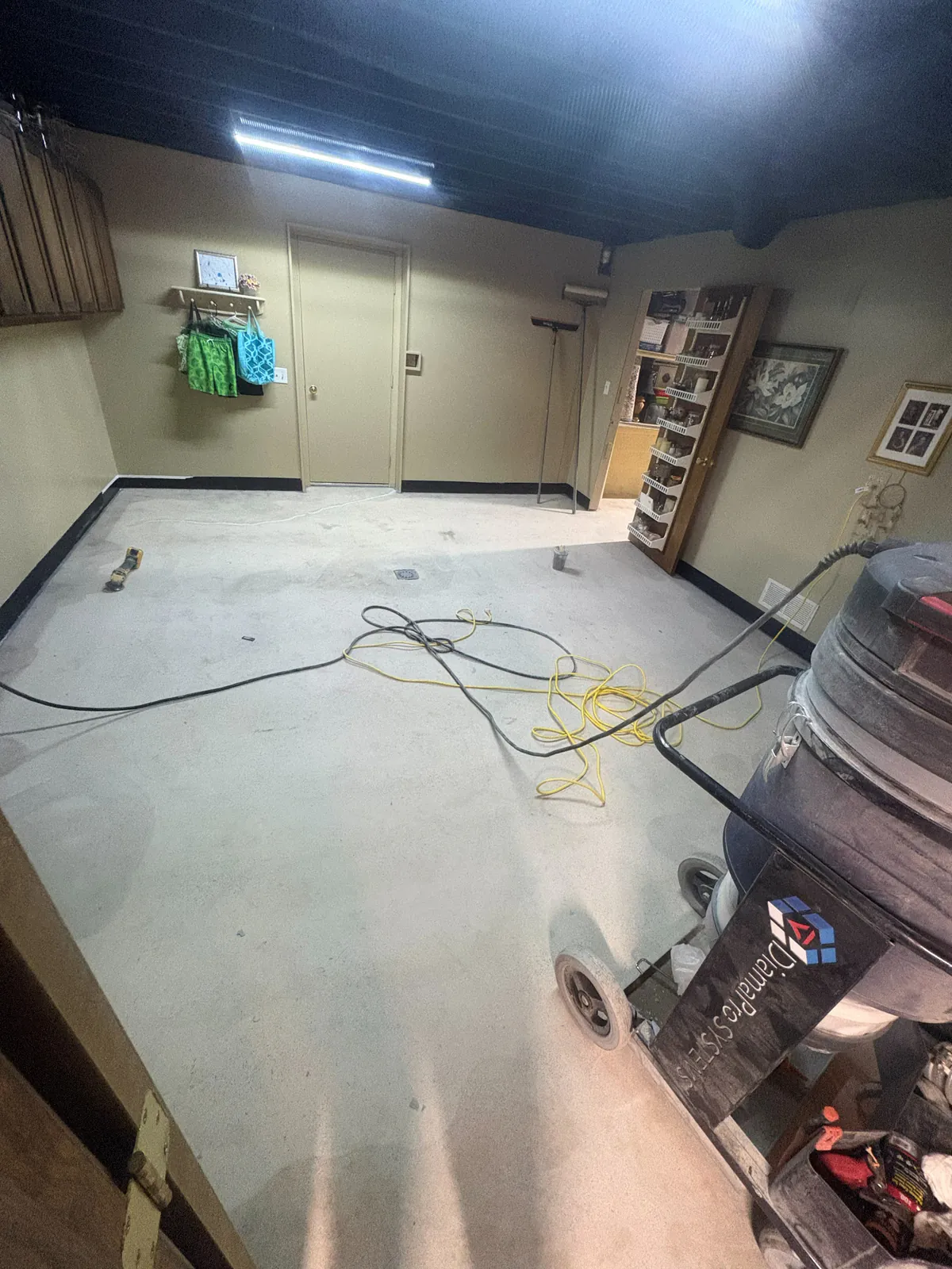 Basement concrete floor during mechanical surface preparation before coating