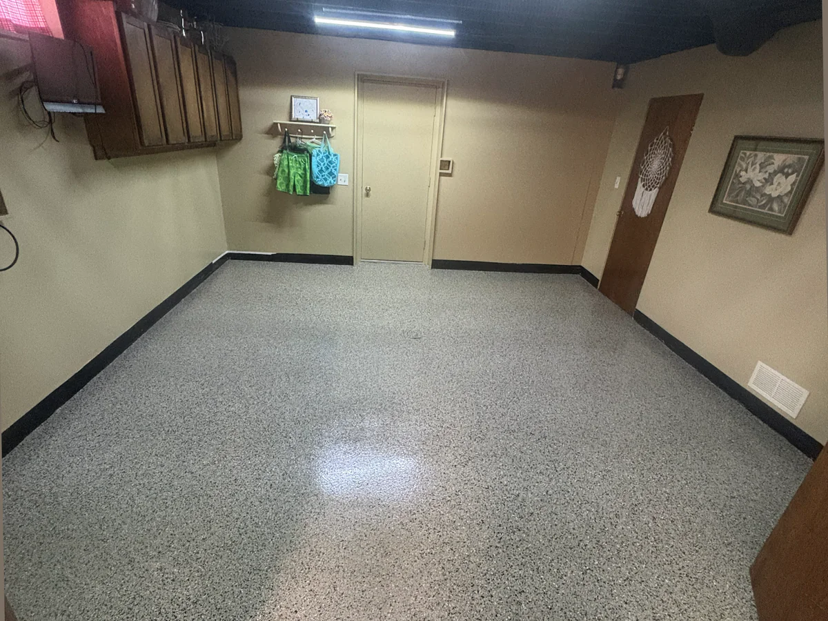 Finished gray decorative flake coating across the basement concrete floor