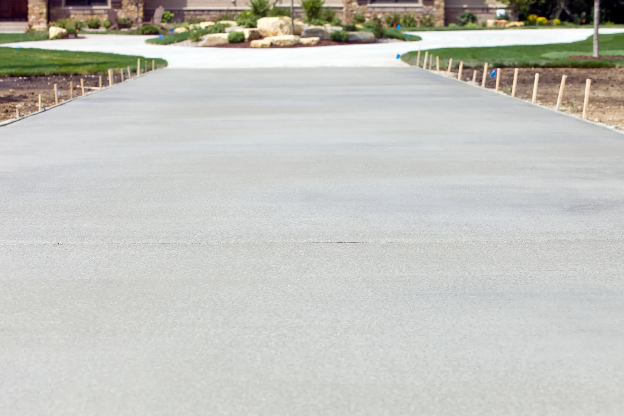 Finished concrete driveway with landscaped residential surroundings