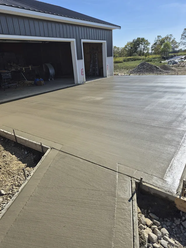 Finished concrete driveway beside a detached residential garage