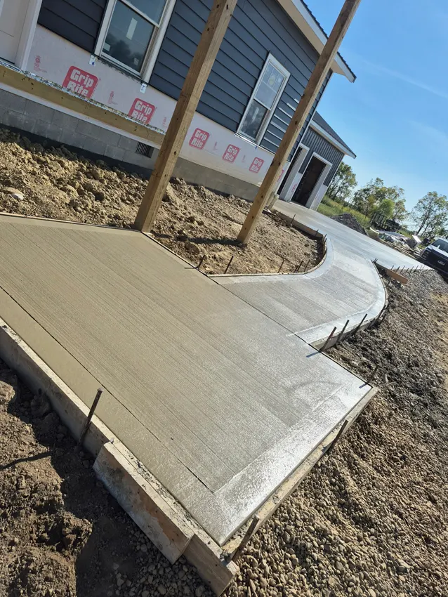 Curved concrete entry walkway beside a residential home